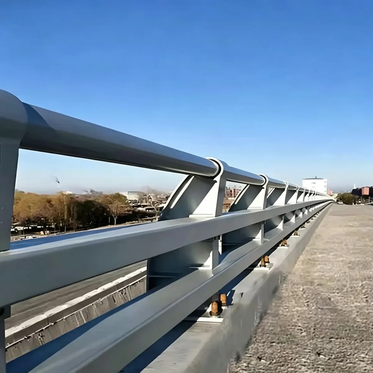 Bridge guardrail with steel posts and base connections on a concrete deck