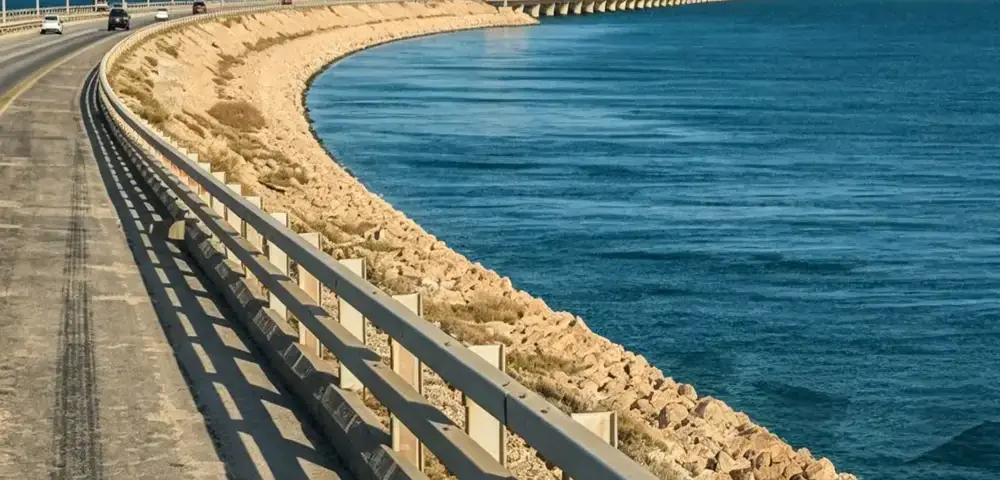 Standard W-beam guardrail installed along a waterfront bridge approach