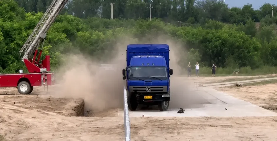 Truck and bus undergoing full-scale guardrail crash tests at a road safety test facility