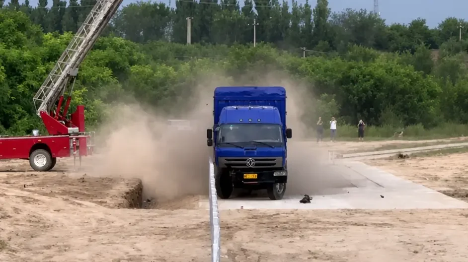Truck and bus undergoing full-scale guardrail crash tests at a road safety test facility