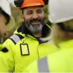 Road construction workers wearing high-visibility safety clothing at a highway work zone